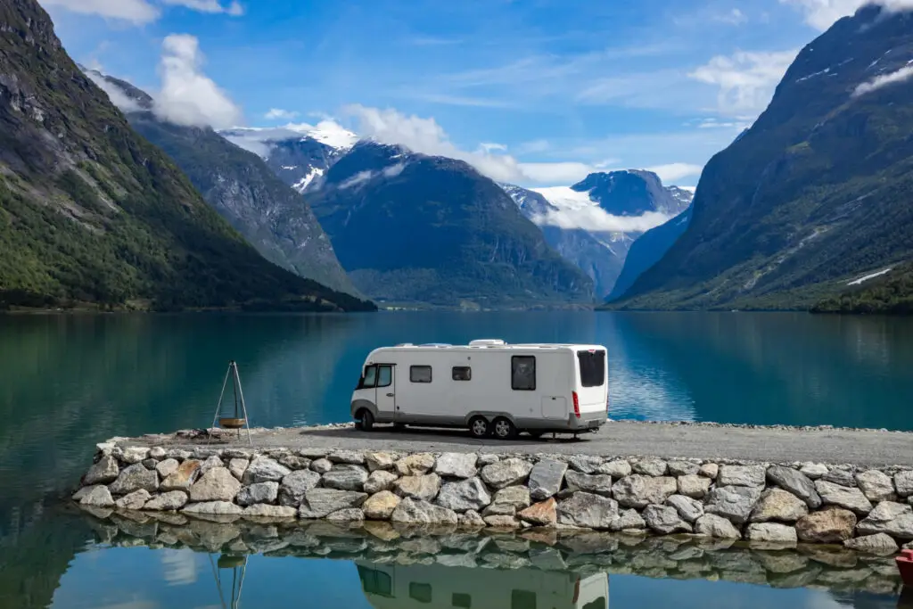 Vollintegriertes Wohnmobil mit Panorama-Frontscheibe vor einem Bergpanorama