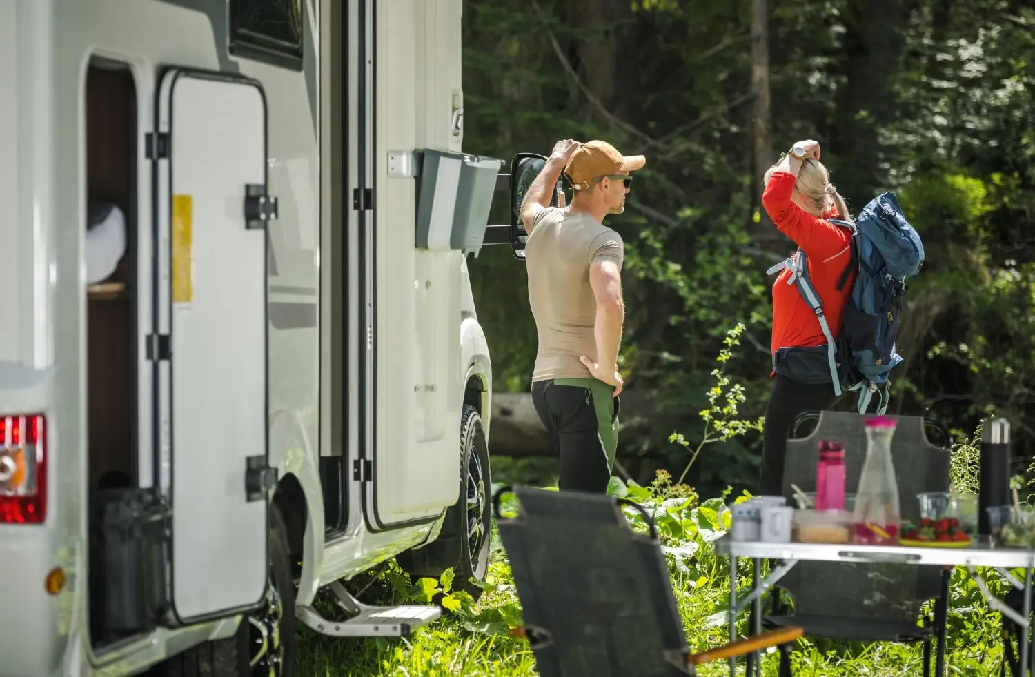 Paar packt Ausrüstung am Wohnmobil – Vorbereitung mit Camping Checkliste